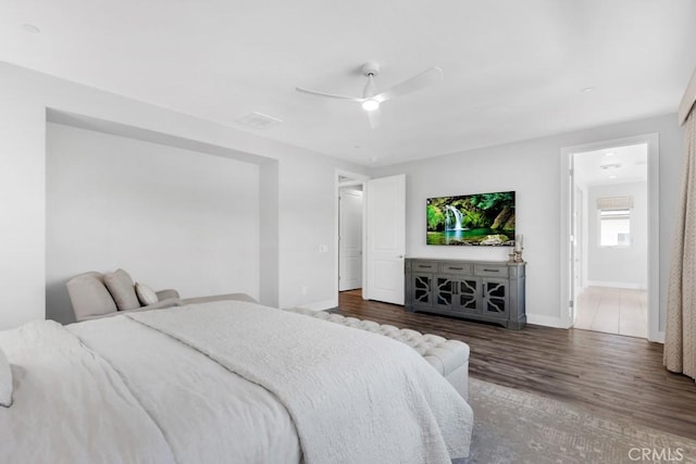 bedroom with ceiling fan, dark wood-type flooring, and connected bathroom