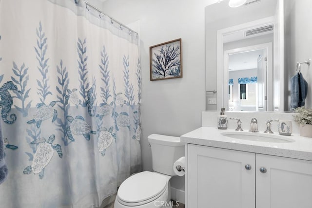 bathroom featuring toilet, vanity, and a shower with shower curtain