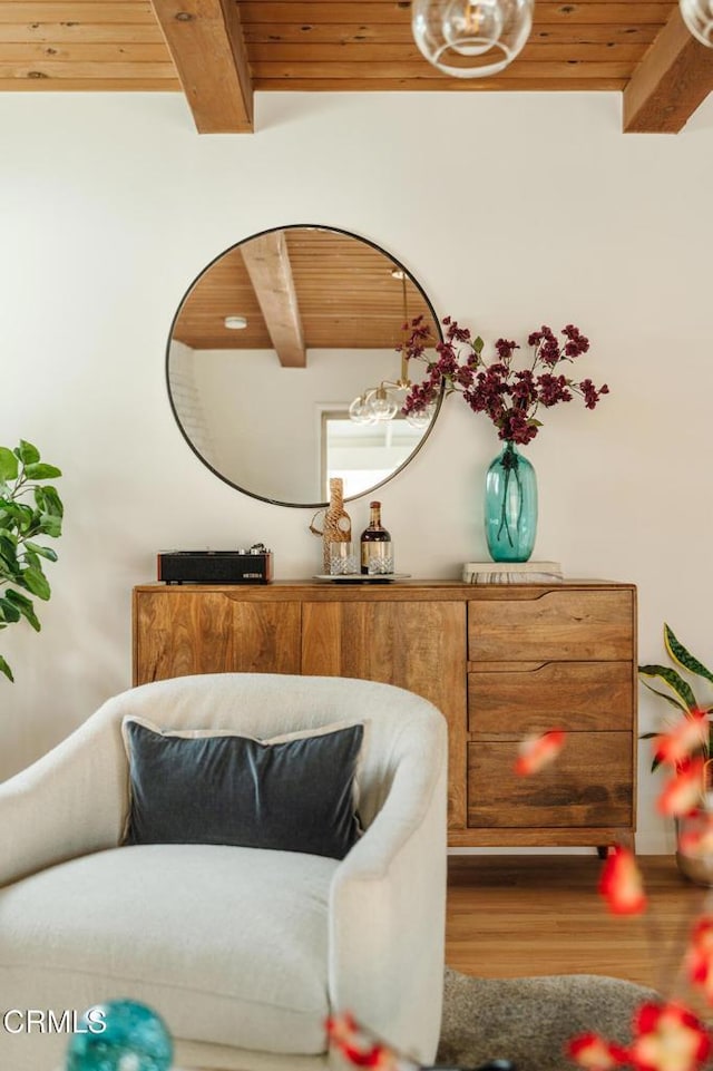 sitting room featuring beam ceiling, wood-type flooring, and wood ceiling