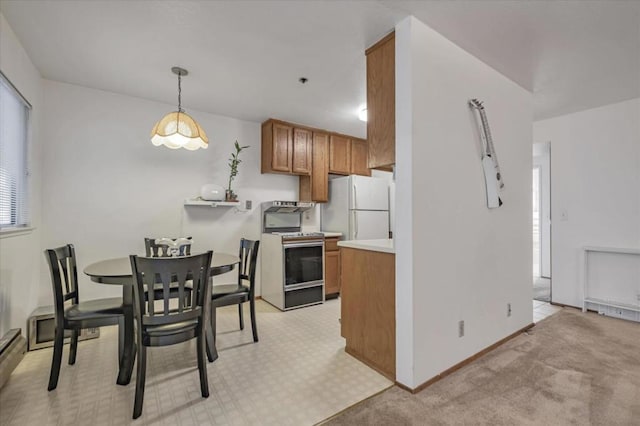 kitchen featuring plenty of natural light, white appliances, hanging light fixtures, and light carpet