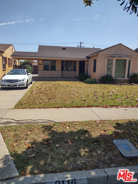 view of front facade featuring a front yard and a carport