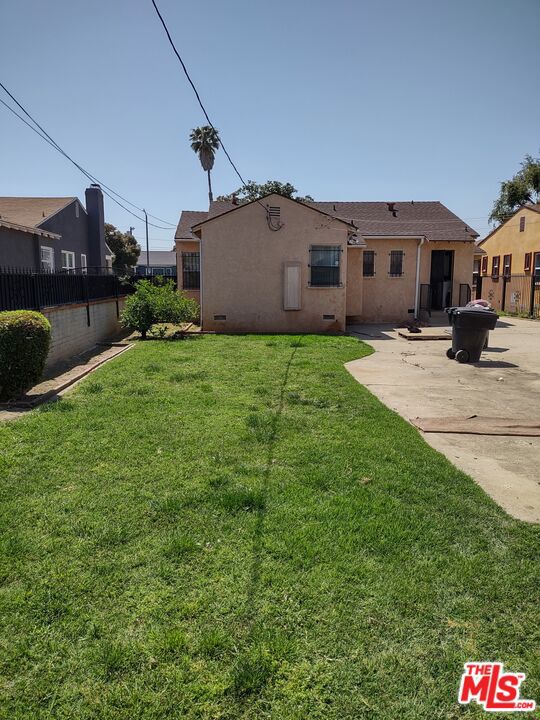 back of property featuring a patio area and a yard