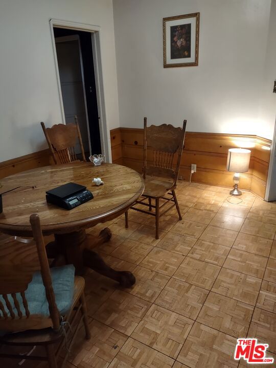 dining room with light parquet flooring and wooden walls