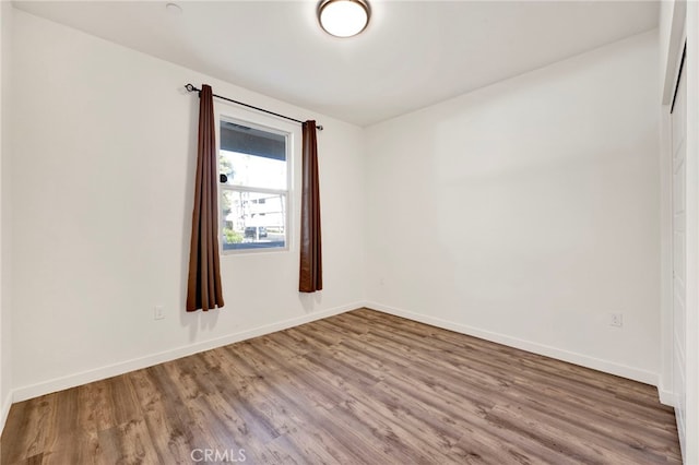 spare room with wood-type flooring