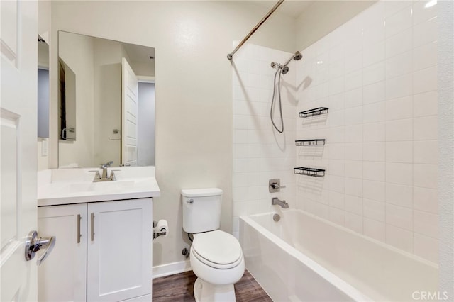 full bathroom with vanity, toilet, tiled shower / bath, and hardwood / wood-style flooring