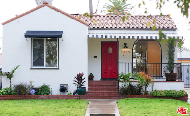 mediterranean / spanish house with a front lawn