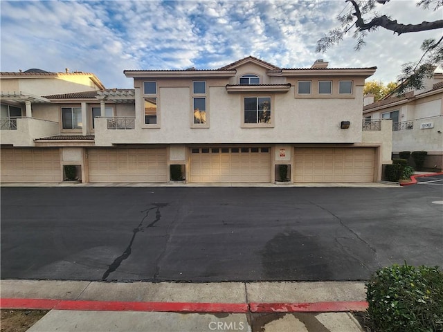 912 N Turner Ave Unit 58, Ontario, CA 91764 - townhome / multi-family property with driveway, stucco siding, an attached garage, and a chimney