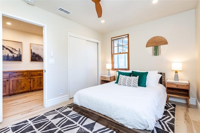 bedroom featuring ceiling fan, a closet, and light wood-type flooring