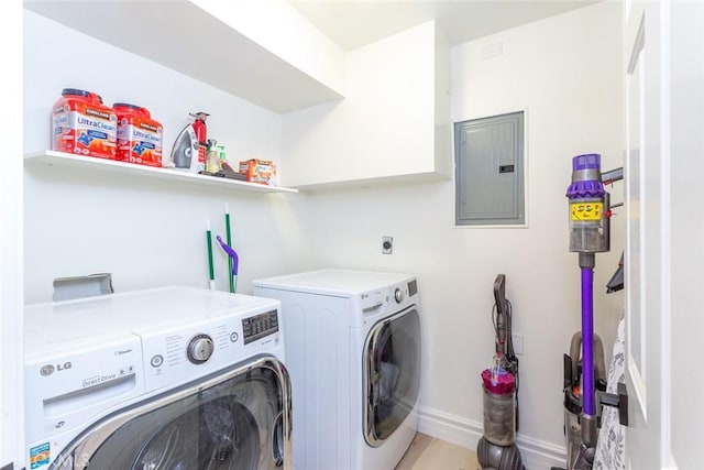 clothes washing area featuring washer and dryer, light hardwood / wood-style floors, and electric panel