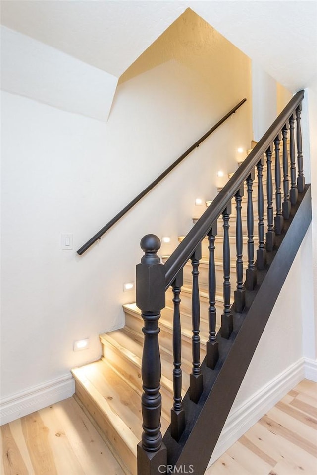 staircase featuring wood-type flooring