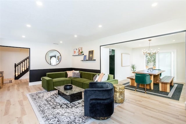 living room featuring light wood-type flooring and a chandelier