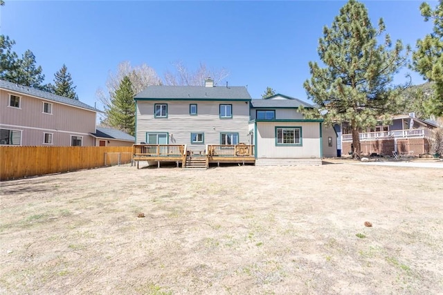 rear view of house featuring a wooden deck