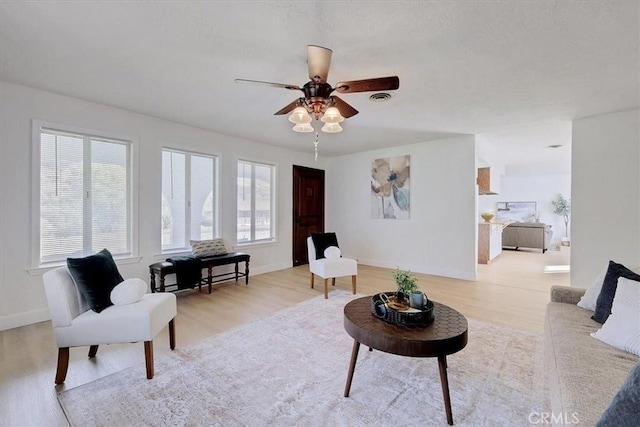 living room with ceiling fan, a healthy amount of sunlight, and light hardwood / wood-style floors