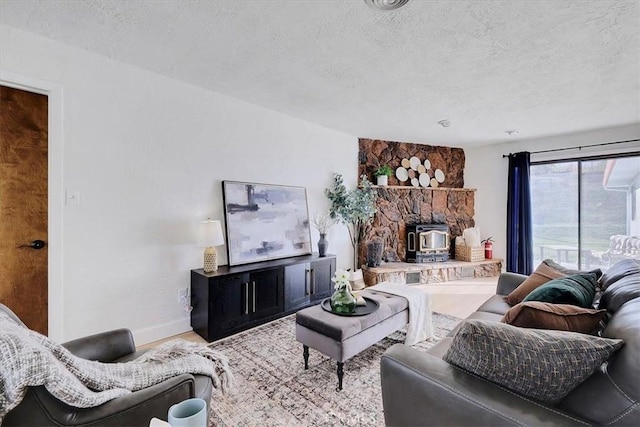 living room featuring a wood stove and a textured ceiling