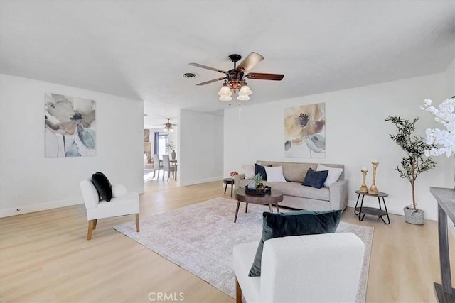 living room with ceiling fan and light hardwood / wood-style flooring