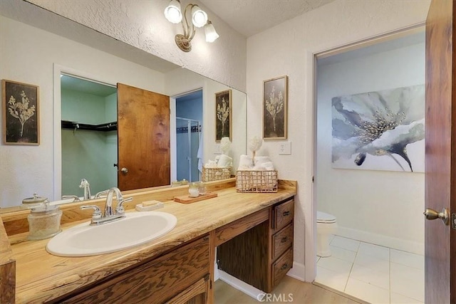 bathroom featuring tile patterned flooring, vanity, and toilet