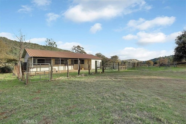 view of yard featuring a mountain view, an outbuilding, and a rural view