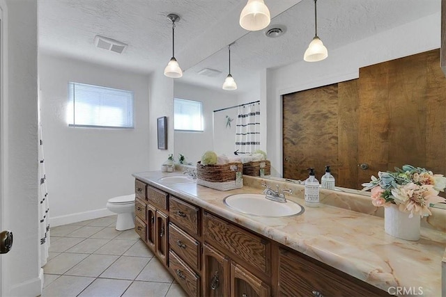 bathroom featuring tile patterned floors, vanity, a textured ceiling, and toilet