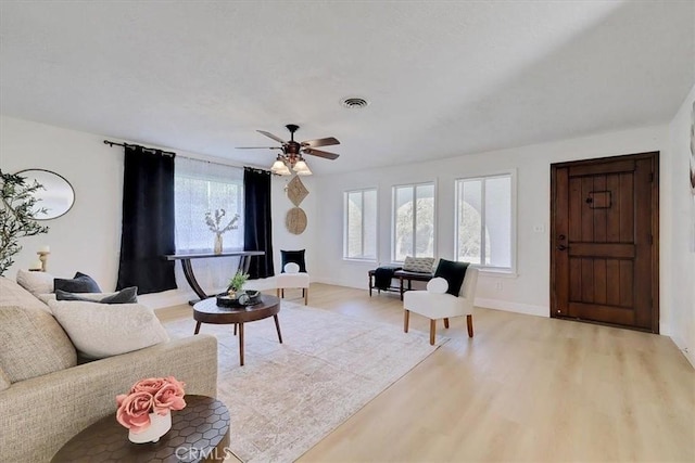 living room with ceiling fan and light hardwood / wood-style flooring