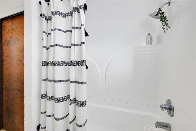 bathroom with shower / bath combo with shower curtain