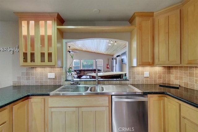 kitchen with arched walkways, vaulted ceiling, stainless steel dishwasher, decorative backsplash, and light brown cabinetry