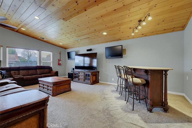 living room with a dry bar, baseboards, vaulted ceiling, and light colored carpet