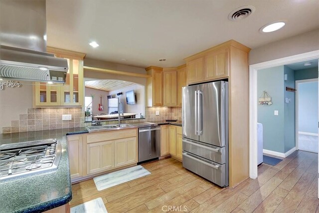 kitchen with visible vents, island exhaust hood, stainless steel appliances, light brown cabinets, and a sink