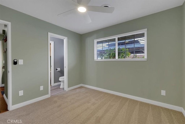 unfurnished bedroom featuring ensuite bath, baseboards, ceiling fan, and carpet flooring