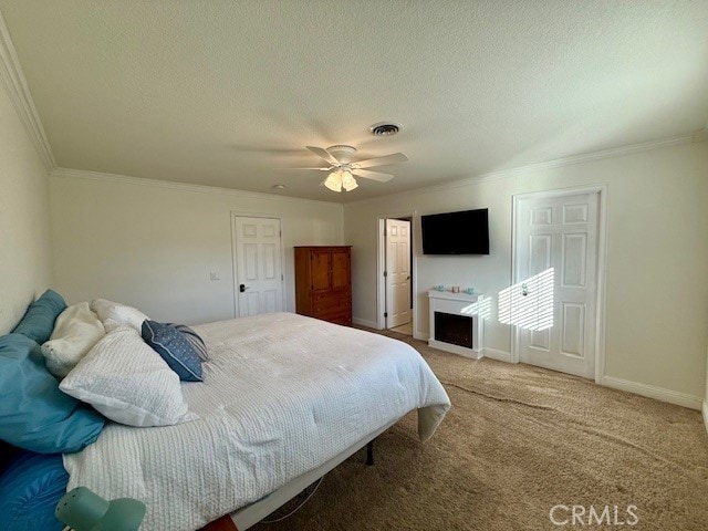 bedroom with baseboards, visible vents, ornamental molding, carpet, and a textured ceiling