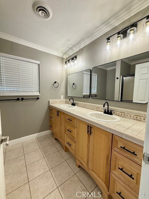 full bathroom featuring ornamental molding, visible vents, a sink, and a textured ceiling