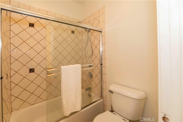 bathroom featuring shower / bath combination with glass door and toilet