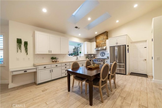 interior space featuring white cabinets, stainless steel appliances, and a skylight