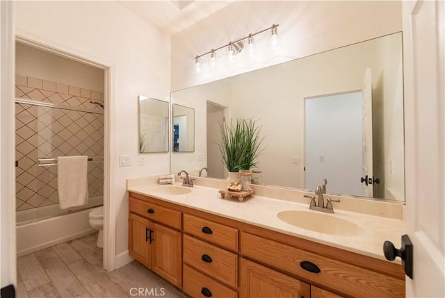 full bathroom with hardwood / wood-style floors, vanity, toilet, and shower / bath combination with glass door