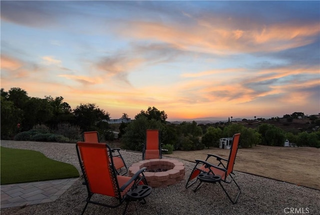 patio terrace at dusk featuring an outdoor fire pit