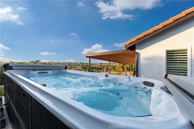 view of swimming pool featuring a hot tub