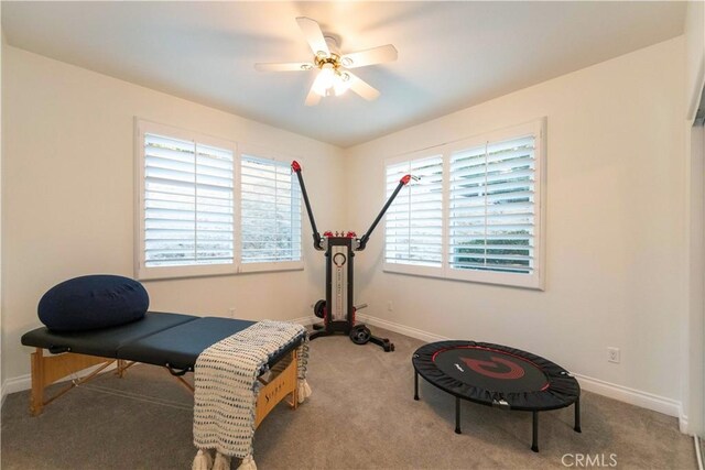 workout area featuring ceiling fan and light carpet