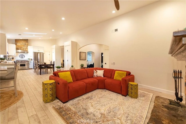 living room featuring light wood-type flooring and high vaulted ceiling