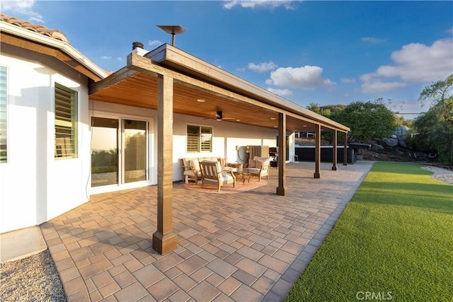 view of patio / terrace featuring an outdoor living space, ceiling fan, and a jacuzzi