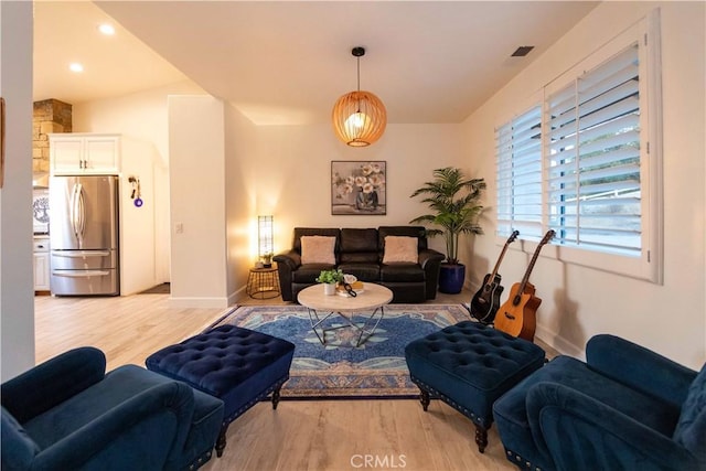 living room featuring vaulted ceiling and light hardwood / wood-style flooring