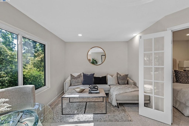 living room with carpet flooring, french doors, and vaulted ceiling