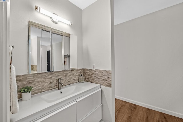 bathroom featuring backsplash, hardwood / wood-style floors, and vanity