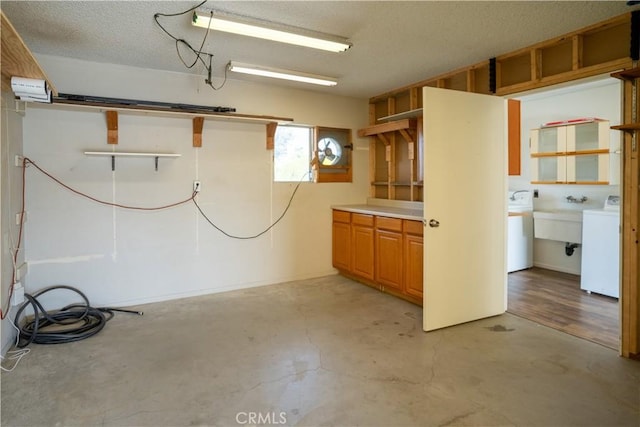 basement featuring a textured ceiling, washer / clothes dryer, and sink