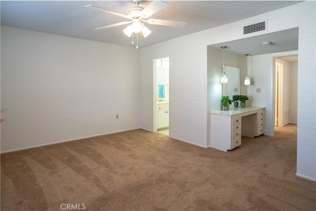 carpeted spare room featuring ceiling fan and a textured ceiling