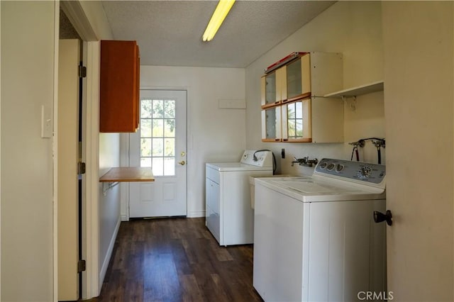 laundry room featuring a textured ceiling, dark hardwood / wood-style flooring, and washing machine and clothes dryer