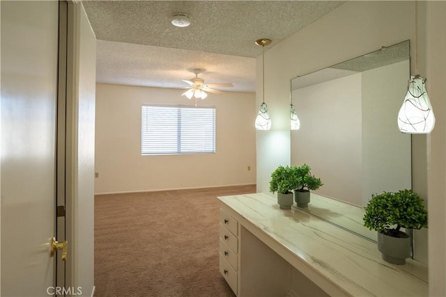 interior space featuring carpet, ceiling fan, and a textured ceiling