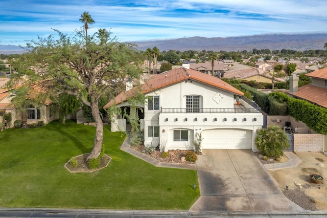 mediterranean / spanish house with a mountain view, a garage, and a front yard