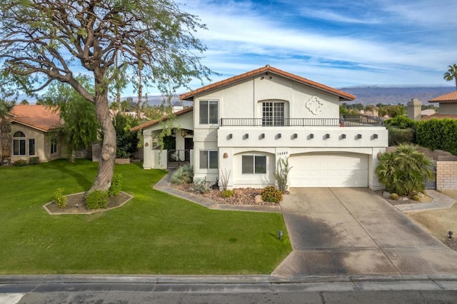 mediterranean / spanish-style home featuring a balcony, a front lawn, and a garage