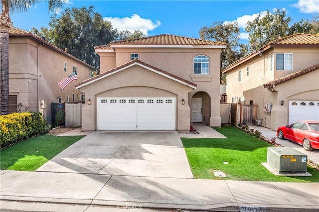 mediterranean / spanish house with a front yard and a garage