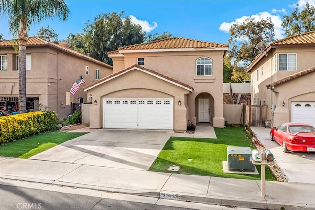 mediterranean / spanish home featuring a garage and a front lawn