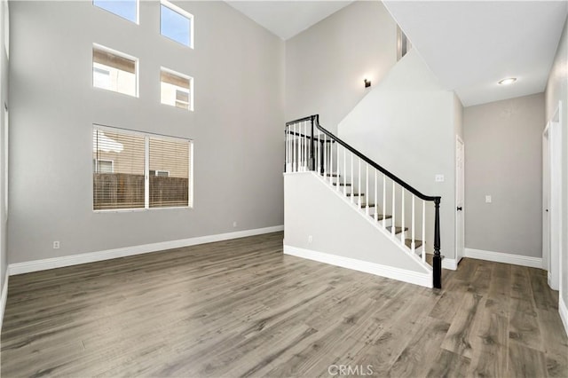 interior space featuring a high ceiling, a wealth of natural light, and hardwood / wood-style floors